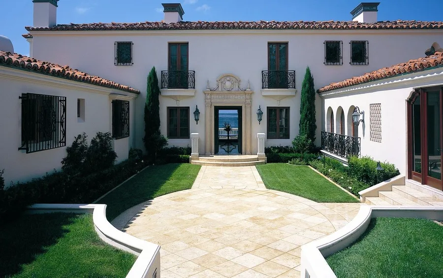 Manicured lawn courtyard with clipped Italian cypress at a Mediterranean estate