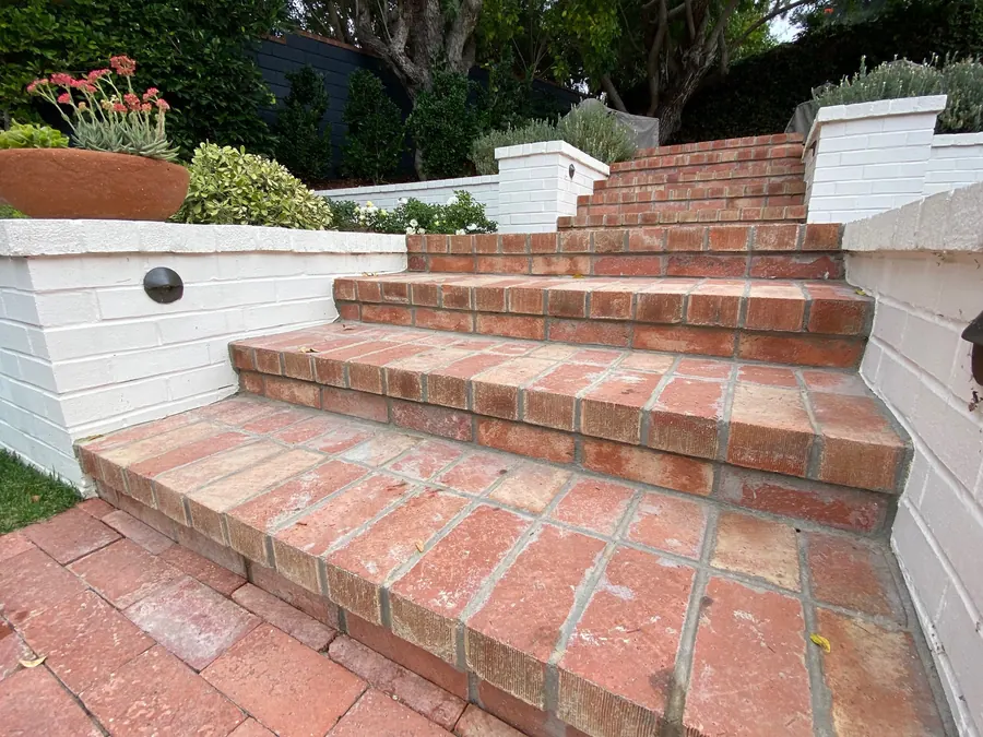 Brick steps and painted masonry walls climbing a terraced garden